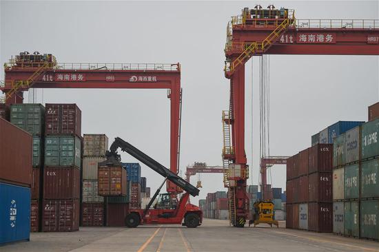 A worker loads containers at the port of Yangpu in South China's Hainan province, April 8, 2020. (Photo/Xinhua)