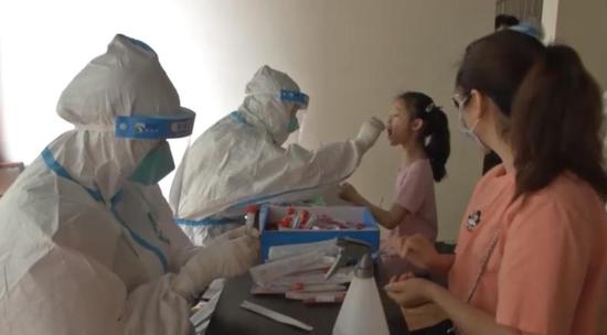 Residents in Wuhan take swabs from a mother and her daughter during a 10-day campaign, May 13, 2020. (CCTV)