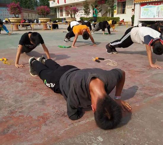 Zhang Jiacheng is doing push-ups with classmates at his school.  (Photo/Xinhua)