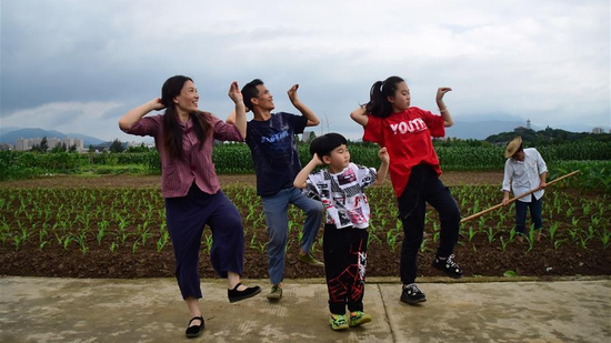 The couple perfom dancing with their kids in the field. (Photo/Xinhua)