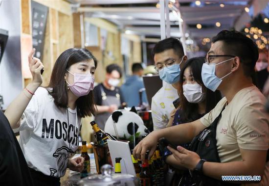 People purchase goods at a night fair in Huangpu District in east China's Shanghai, June 6, 2020. Shanghai kicked off a night festival on Saturday to boost the city's night economy. A number of bars, museums, bookstores, shopping malls and landmark commercial complexes joined the festival with extended business hours and themed activities like night tours, shopping, dining, reading and live shows. (Xinhua/Ding Ting)