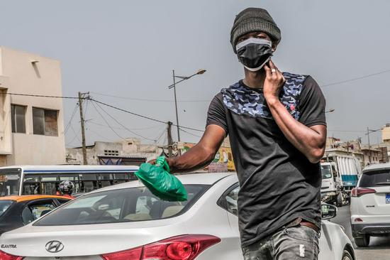 A man wearing a face mask walks on a street in Dakar, Senegal, June 3, 2020. (Xinhua/Eddy Peters)