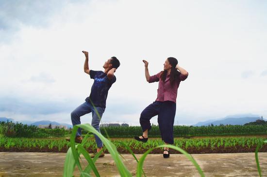 Fan Deduo (left) and his wife, Peng Xiaoying, dance beside their field in Ruian, Zhejiang province, this month. (Photo/Xinhua)