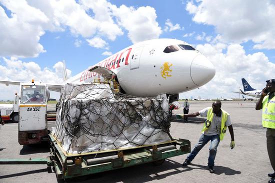 An airport authority worker pulls a consignment of medical equipment donation for COVID-19 that was donated by Jack Ma and Alibaba Foundations to Kenya, at Jomo Kenyatta International Airport in Nairobi, Kenya, March 24, 2020. (Xinhua/John Okoyo)