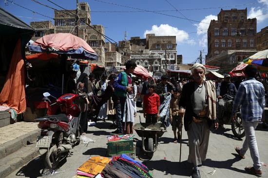 People shop at a market in Sanaa, Yemen, April 17, 2020. In a virtual briefing to the UN Security Council, UN Undersecretary-General for Humanitarian Affairs Mark Lowcock warned that the disruption of imports and the expected drop of remittances as a result of COVID-19, as well as the drying up of foreign exchange as a result of lower oil prices, will bring disasters. (Photo by Mohammed Mohammed/Xinhua)