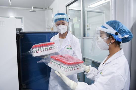 Staff members hold inactivated samples for nucleic acid test at the laboratory of KingMed Diagnostics, a Chinese medical diagnostic testing company in Beijing, capital of China, June 25, 2020. (Xinhua/Ju Huanzong)