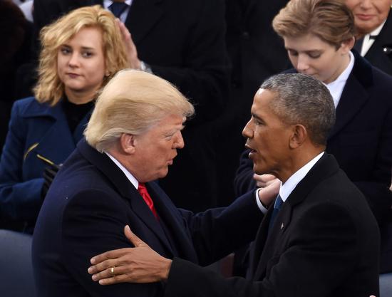Photo taken on Jan. 20, 2017 shows U.S. President Donald Trump (L, front) being greeted by former U.S. President Barack Obama after delivering his inaugural address during the presidential inauguration ceremony at the Capitol in Washington, D.C., the United States. (Xinhua/Yin Bogu)
