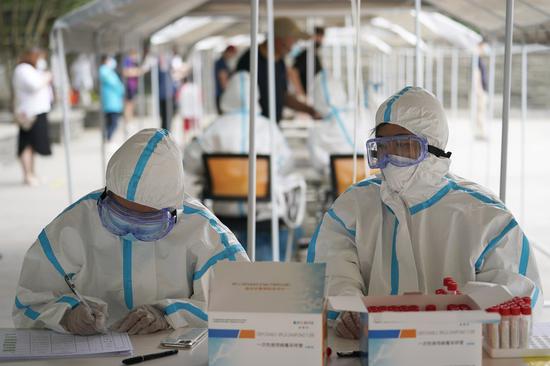 Medical workers work at a nucleic acid testing site in Shoupakou South Street of Xicheng District, Beijing, capital of China, June 24, 2020. (Xinhua/Xing Guangli)