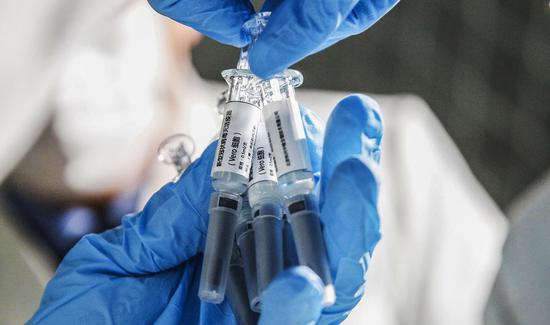 A staff member displays samples of the COVID-19 inactivated vaccine at Sinovac Biotech Ltd., in Beijing, capital of China, March 16, 2020. (Xinhua/Zhang Yuwei)