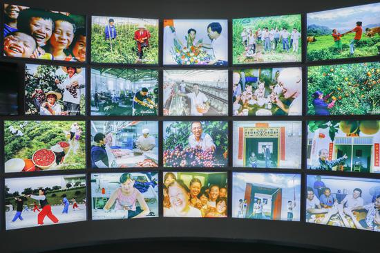 Photo taken on June 22, 2020 shows a photo wall displaying the happy life of people who have settled down after their relocation from the Three Gorges Reservoir area at the Three Gorges Migration Memorial in Wanzhou District, southwest China's Chongqing Municipality. (Xinhua/Huang Wei)