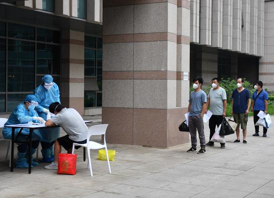 People who finished quarantine wait to get documents before leaving a designated quarantine site in Beijing, capital of China, July 11, 2020. (Xinhua/Zhang Chenlin)