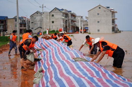 Rescuers build a temporary waterproof dike to stop the flood at Jiangjialing Village in Poyang County, east China's Jiangxi Province, July 11, 2020. (Xinhua/Zhang Haobo)