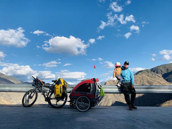 Dou Haobei and his daughter pose for a photo during their bike ride to Tibet, May 18, 2020. (Xinhua)