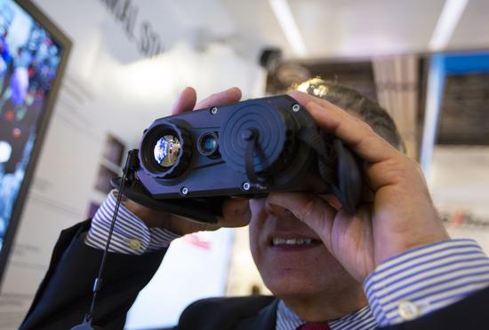 A staff member of China's Hikvision shows a thermal-optical binocular camera at the International Security Conference and Exposition (ISC West) in Las Vegas, the United States, April 10, 2019.(Xinhua/Li Ying)
