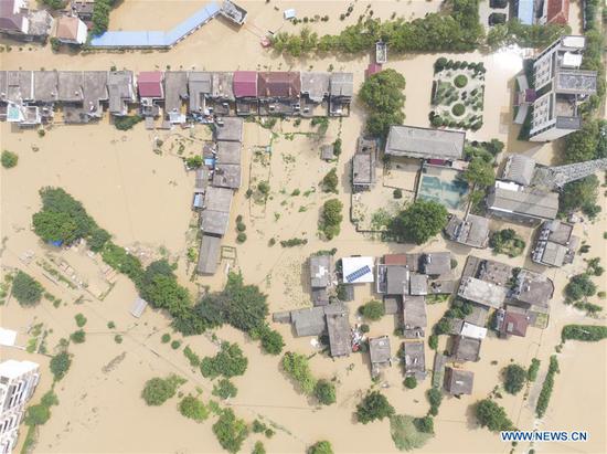 Aerial photo taken on July 13, 2020 shows the flooded village in Sanjiao Township in Yongxiu County, east China's Jiangxi Province. The embankment of a river in Yongxiu County was breached Sunday night following continuous torrential rains, forcing local residents to evacuate. (Xinhua/Zhang Haobo)