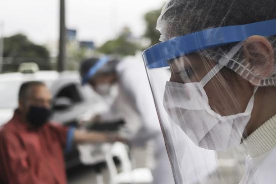 Medical workers in personal protective equipment are on duty to perform COVID-19 rapid tests for taxi drivers in Sao Paolo, Brazil, June 26, 2020. (Xinhua/Rahel Patrasso)