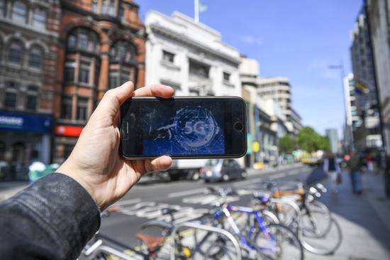 Photo taken on May 30, 2019 shows a 5G network logo on the screen of a mobile phone in London, Britain. (Xinhua/Alberto Pezzali)