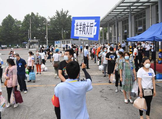 People who finished quarantine wait for shuttle bus to retrieve their personal belongings at Xinfadi market in Fengtai District of Beijing, capital of China, July 11, 2020. (Xinhua/Zhang Chenlin)