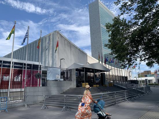 A woman walks with a baby stroller in front of the United Nations (UN) headquarters in New York, the United States, July 20, 2020. (Xinhua/Wang Jiangang)