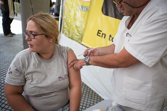 A woman receives a vaccine for Hepatitis B at a stand during a fair for basic services in prevention of disease in the context of the World Health Day's commemoration, in Buenos Aires, Argentina, on April 7, 2015. (Xinhua File/Martin Zabala)