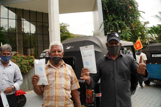 Local three-wheel drivers pose with face masks during a donation ceremony in Colombo, Sri Lanka, July 29, 2020. (Xinhua/Tang Lu)