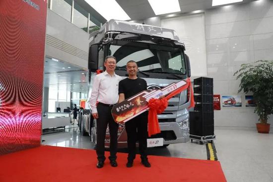 Sun Gang(R), a driver who has risked his life driving a burning truck away from a populated area to prevent casualties, receives a new truck for his lost vehicle, July 31, 2020. (Xinhua/Zhang Jian)