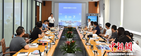 Liu Yigong, Member of the Board of Directors, Secretary of the Party Committee and President of FAW-Volkswagen Automotive Co.，Ltd., exchanges ideas with journalists