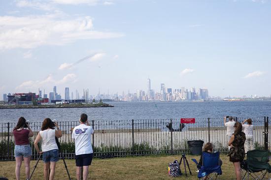 People watch a military flyover that takes place above New York City, July 4, 2020. (Photo: China News Service / Wang Fan)