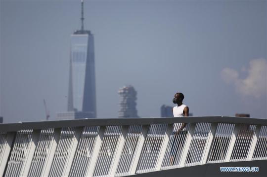 A man walks on a platform along the East River in New York, the United States, on Aug. 9, 2020. The total number of COVID-19 cases in the United States surpassed the 5 million mark on Sunday, according to the Center for Systems Science and Engineering (CSSE) at Johns Hopkins University. (Xinhua/Wang Ying)
