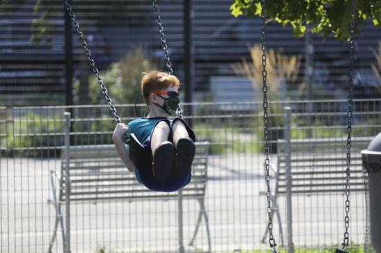 A boy plays on a swing at a playground in New York, the United States, on Aug. 9, 2020. (Xinhua/Wang Ying)