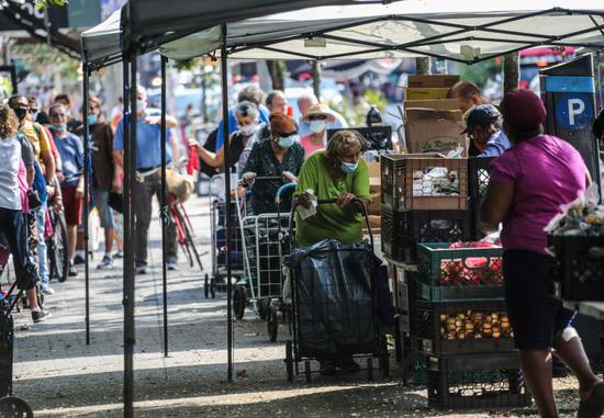 People collect food at a free food distribution site in New York, the United States, Aug. 8, 2020. (Xinhua/Wang Ying)