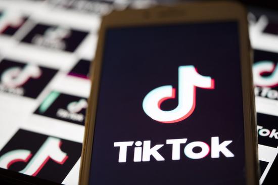 The logo of TikTok is displayed on the screen of a smartphone on a computer screen background in Arlington, Virginia, the United States, Aug. 3, 2020. (Xinhua/Liu Jie)