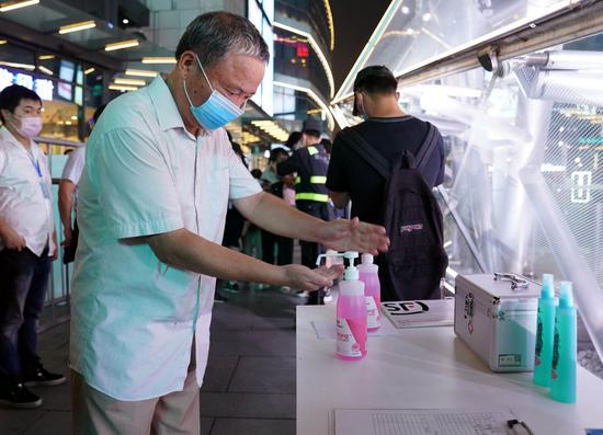 A man disinfects hands before entering the outdoor screening site during the Shanghai International Film Festival in Shanghai, east China, July 25, 2020. (Xinhua/Liu Ying)