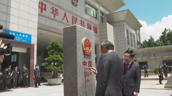 The foreign ministers trace in red ink over characters printed on each county's first boundary stone.(Photo provided to China News Service)