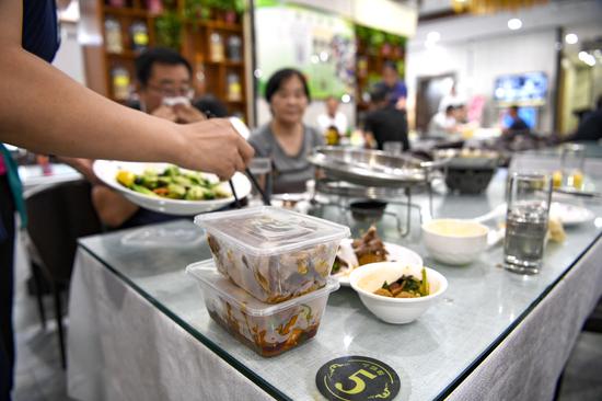 A waitress packages leftovers for customers at a restaurant in Yinchuan, Ningxia Hui autonomous region, Aug 16, 2020. [Photo/Xinhua]