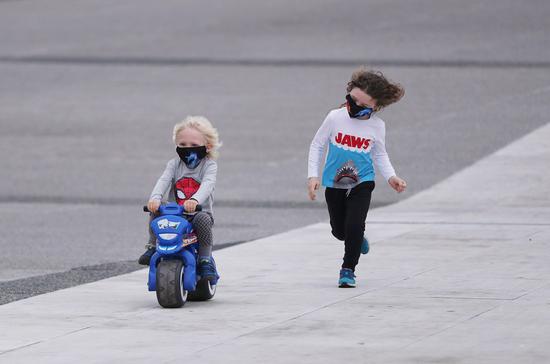 Children wearing face masks play on a street in Paris, France, Aug. 20, 2020. (Xinhua/Gao Jing)