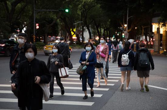 People wearing masks walk on street in Taipei, southeast China's Taiwan, March 30, 2020. (Xinhua/Jin Liwang)