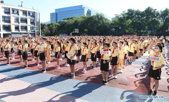 Students take part in a flag-raising ceremony at Beijing No. 2 Experimental Primary School in Beijing, capital of China, Sept. 1, 2020. Students in Beijing kicked off a new school year on Tuesday. (Xinhua/Ren Chao)