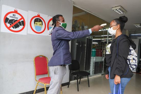 A guard checks a customer's temperature at a shopping mall in Addis Ababa, capital of Ethiopia, Aug. 27, 2020. (Xinhua/Michael Tewelde)