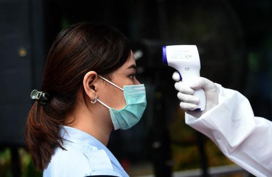A staff member of Indonesian Directorate General of Immigration has her temperature checked before COVID-19 tests in Jakarta, Indonesia, Aug. 24, 2020. (Xinhua/Zulkarnain)