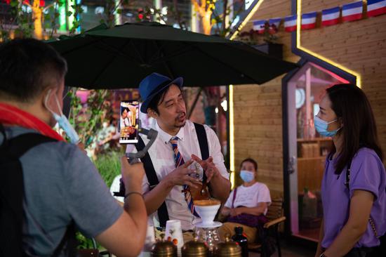 A coffee shop staff member (C) attends a livestreamed interview during a shopping carnival held in the Wangjing subdistrict as part of a consumption stimulus plan in Chaoyang District, Beijing, capital of China, Aug. 8, 2020. (Xinhua/Chen Zhonghao)