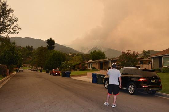 A man watches the wildfire in Angeles National Forest, Monrovia, Los Angeles, the United States, Sept. 10, 2020. (Xinhua/Gao Shan)