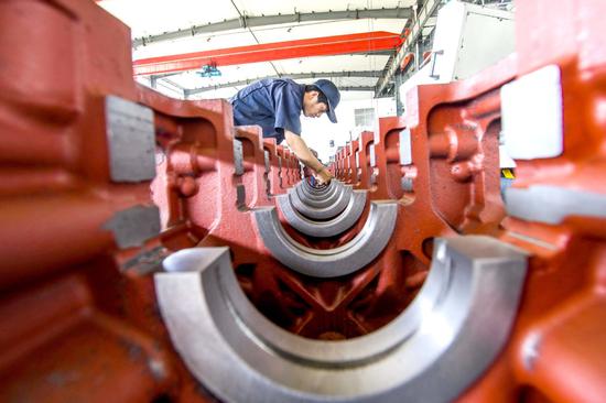 A technician calibrates equipment at a manufacturing plant in Qingzhou, Shandong province. (Photo by Wang Jilin/For China Daily)