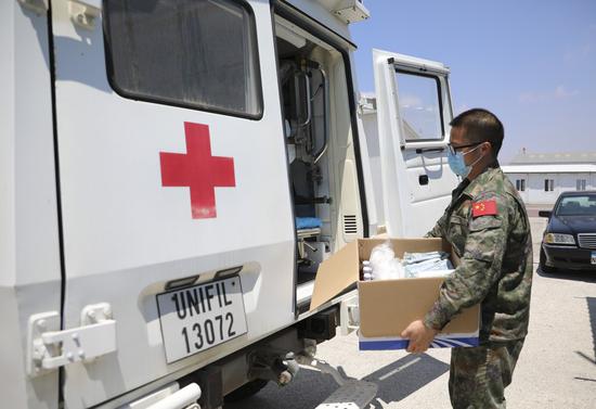 A health worker carries medical supply at the camp site of the Chinese peacekeeping troops to Lebanon in southern Lebanon, Aug. 5, 2020. (Photo by Huang Shifeng/Xinhua)