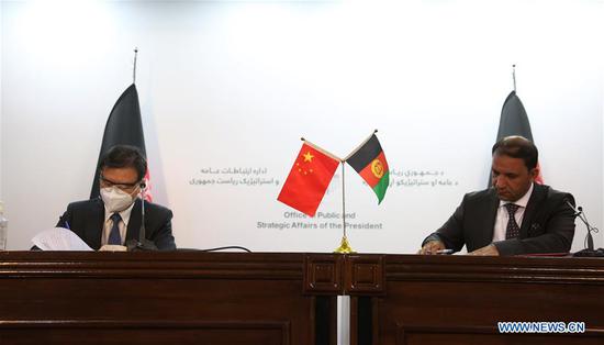 Chinese Ambassador to Afghanistan Wang Yu (L) and Ghulam Bahauddin Jailani, Afghan State Minister for Disaster Management and Humanitarian Affairs, sign the agreement during a hand-over ceremony in Kabul, capital of Afghanistan, Sept. 20, 2020. China provided a batch of non-emergency humanitarian supplies to the Afghan government at a hand-over ceremony held here in Kabul on Sunday. (Photo by Rahmatullah Alizadah/Xinhua)