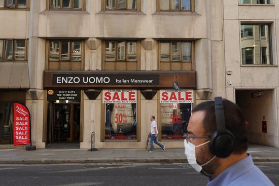 People walk past a clothing store in London, Britain, on Sept. 16, 2020. (Photo by Tim Ireland/Xinhua)