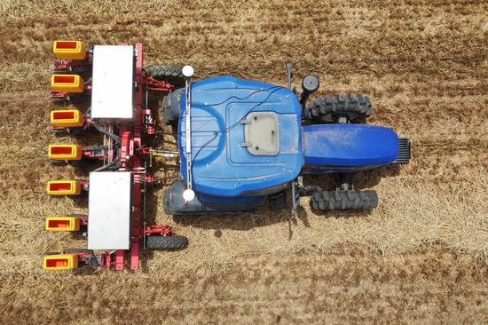Photo taken on May 26, 2020 shows an unmanned tractor equipped with BeiDou Navigation Satellite System (BDS) sowing seeds in the field in Anzhong Village of Xiaoyangying Town in Dengzhou City, central China's Henan Province. (Xinhua/Feng Dapeng)