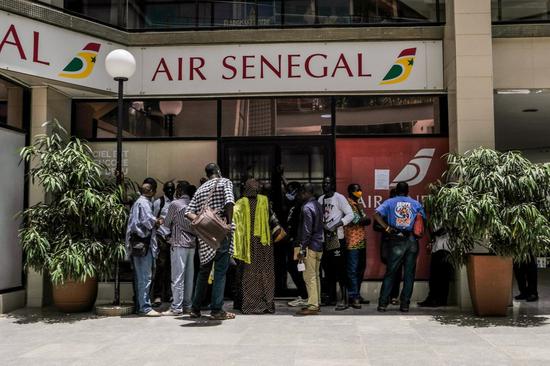 Customers wait outside a ticket office of Air Senegal in central Dakar, Senegal, on July 21, 2020. (Xinhua/Eddy Peters)