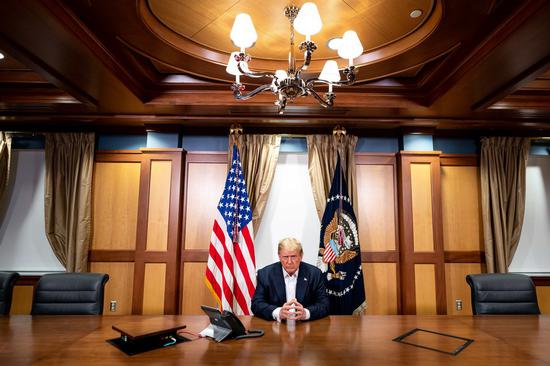 Image provided by the White House shows U.S. President Donald Trump participating in a phone call with Vice President Mike Pence, Secretary of State Mike Pompeo, and Chairman of the Joint Chiefs of Staff General Mark Milley from a conference room at Walter Reed National Military Medical Center in Bethesda, Maryland, the United States, on Oct. 4, 2020. (Tia Dufour/The White House/Handout via Xinhua)