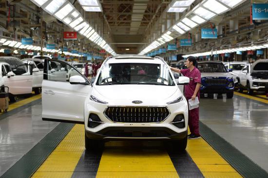 A worker exams a newly assembled car at the passenger vehicle assembly plant of Anhui Jianghuai Automobile Group Corp., Ltd. in Hefei, east China's Anhui Province, June 19, 2020. (Xinhua/Huang Bohan)